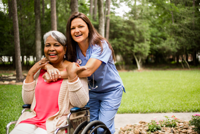 Senior woman in wheelchair with nurse.